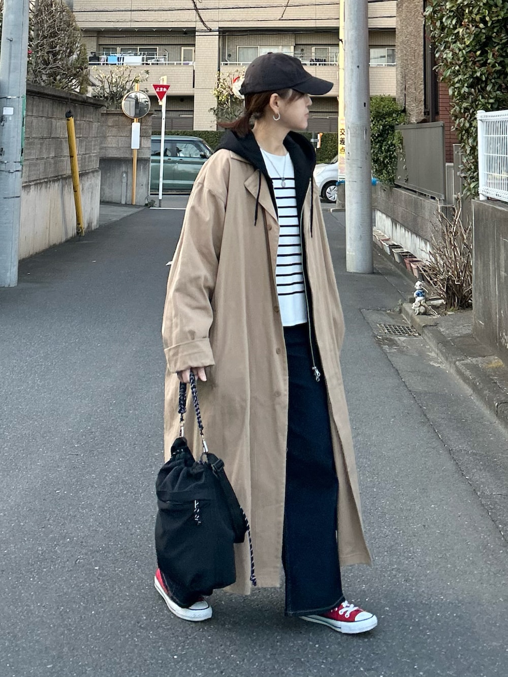 ホワイト系のニット/セーター、ブルー系のデニムパンツ、ブラック系のトートバッグを着用したレディースの春コーディネートの3枚目の写真