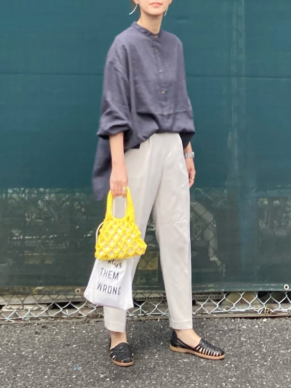 グレー系のシャツ/ブラウス、ホワイト系のスラックス、イエロー系のハンドバッグを着用したレディースの春コーディネートの5枚目の写真