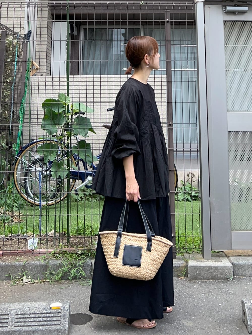 ブラック系のシャツ/ブラウス、ブラック系のスカート、ブラック系のかごバッグを着用したレディースの夏コーディネートの2枚目の写真