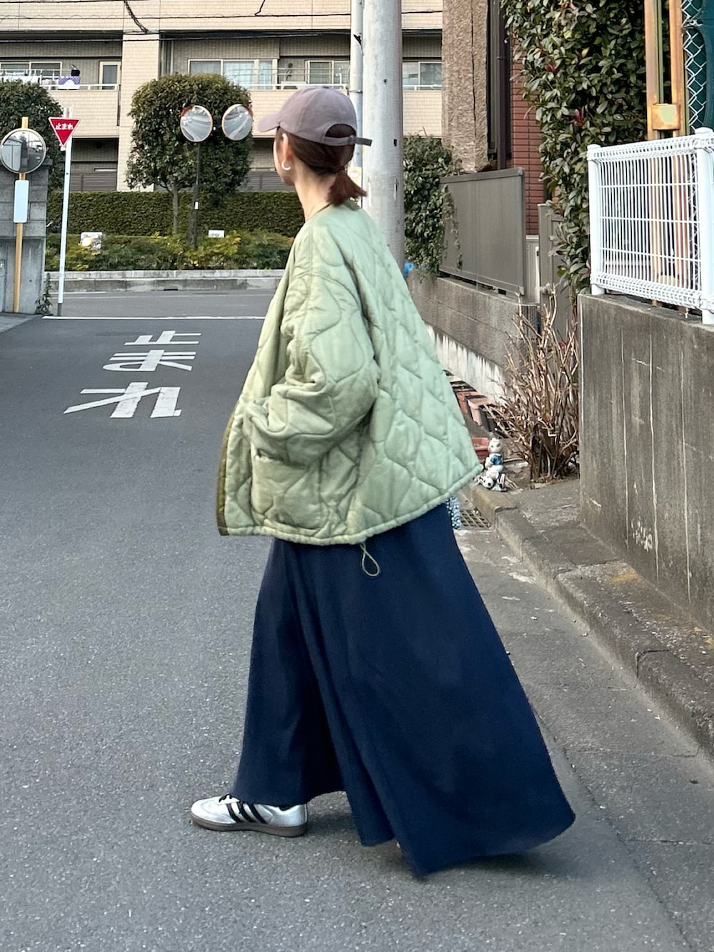 ブルー系のワンピース、グリーン系のノーカラージャケット、シルバー系のスニーカーを着用したレディースの冬コーディネートの4枚目の写真