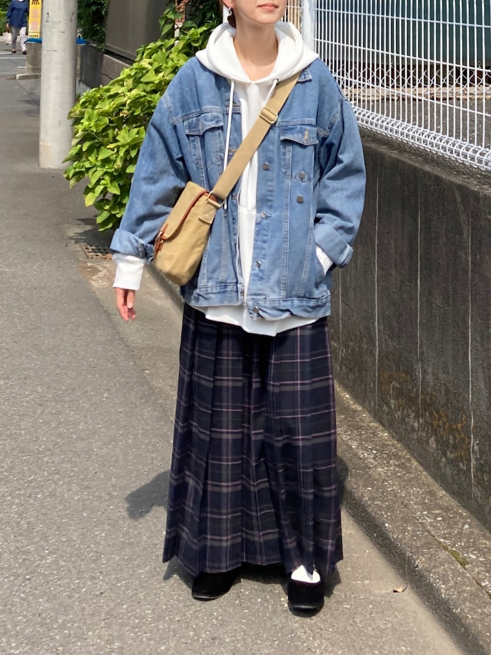 ホワイト系のパーカー、ブルー系のデニムジャケット、ブルー系のスカートを着用したレディースの秋コーディネートの2枚目の写真
