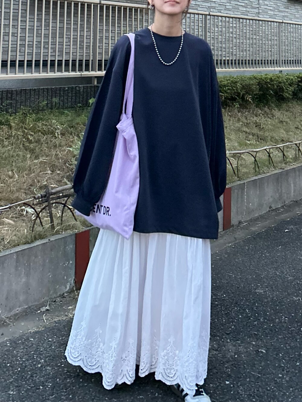 ブルー系のTシャツ/カットソー、ホワイト系のスカート、パープル系のトートバッグを着用したレディースの秋コーディネートの4枚目の写真