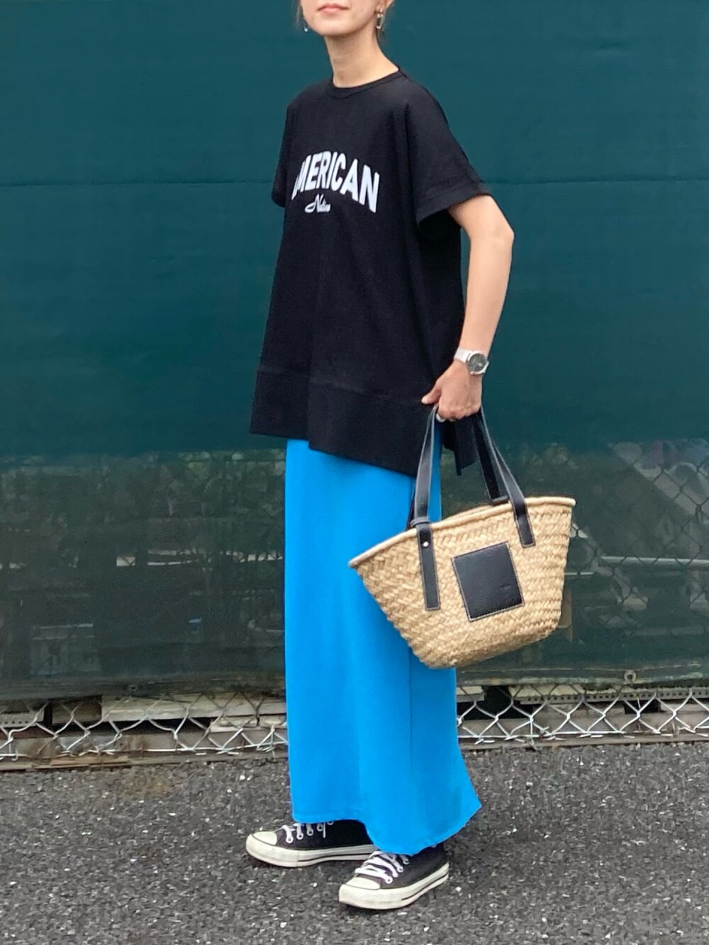 ブラック系のTシャツ/カットソー、ブルー系のスカート、ブラック系のかごバッグを着用したレディースの夏コーディネートの2枚目の写真