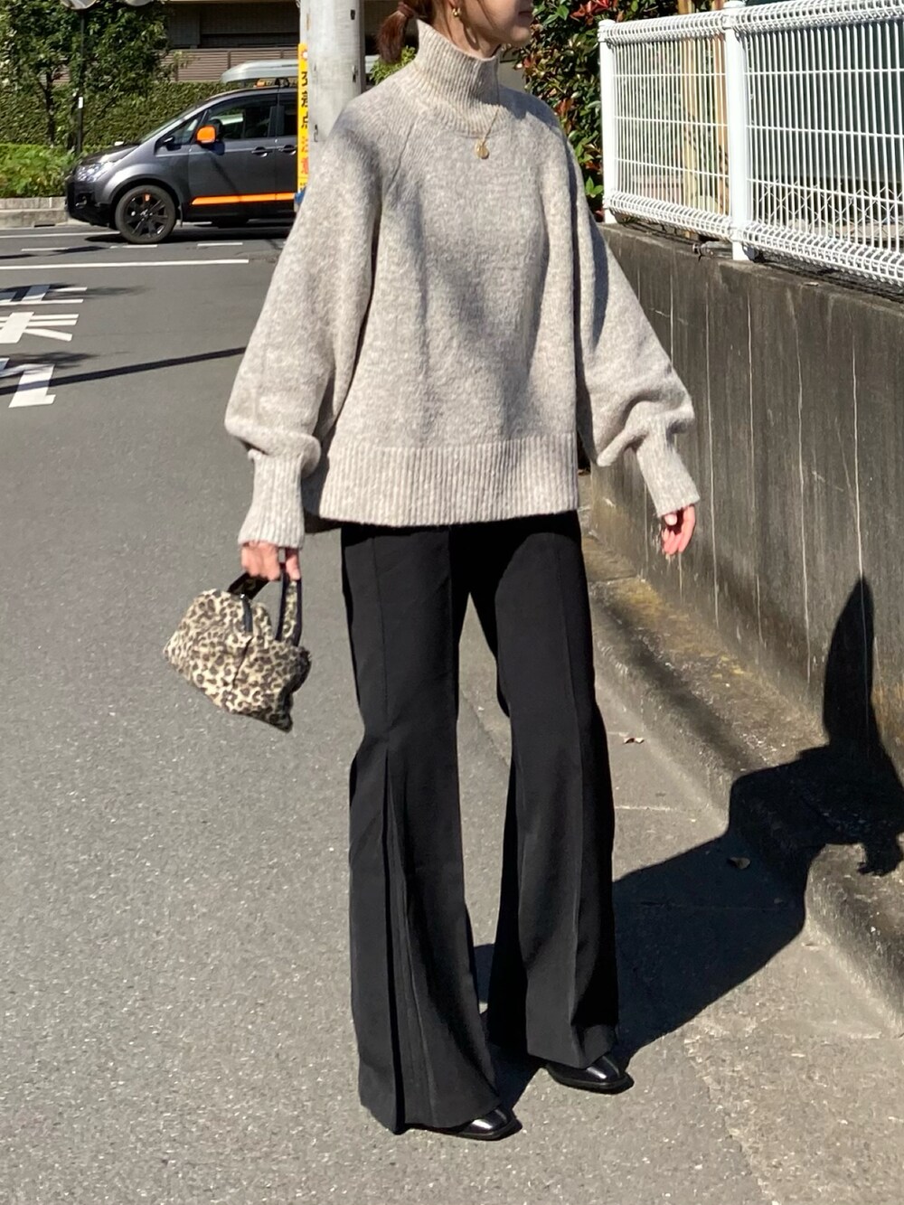 ホワイト系のニット/セーター、ブラック系のその他パンツ、ブラック系のブーツを着用したレディースの秋コーディネートの4枚目の写真