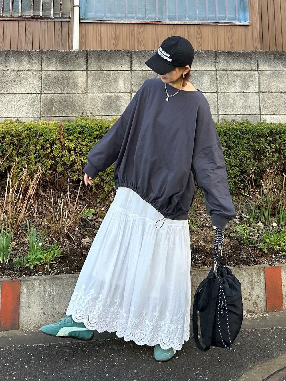 グレー系のTシャツ/カットソー、ブラック系のトートバッグ、ホワイト系のスカートを着用したレディースの冬コーディネートの5枚目の写真