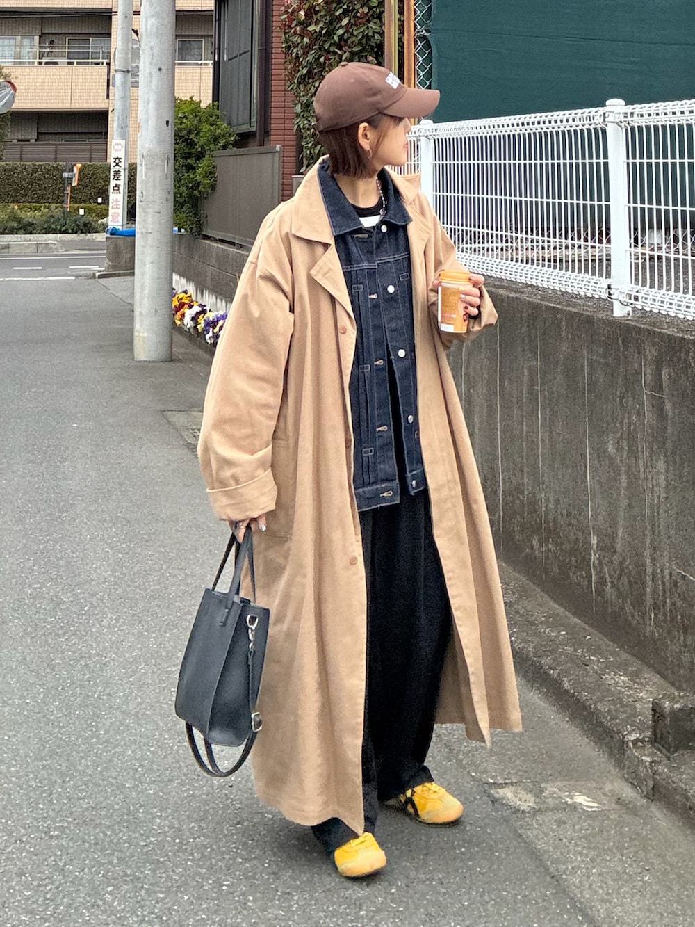 ブルー系のデニムジャケット、ブラック系のスラックス、ブラック系のショルダーバッグを着用したレディースの春コーディネートの2枚目の写真