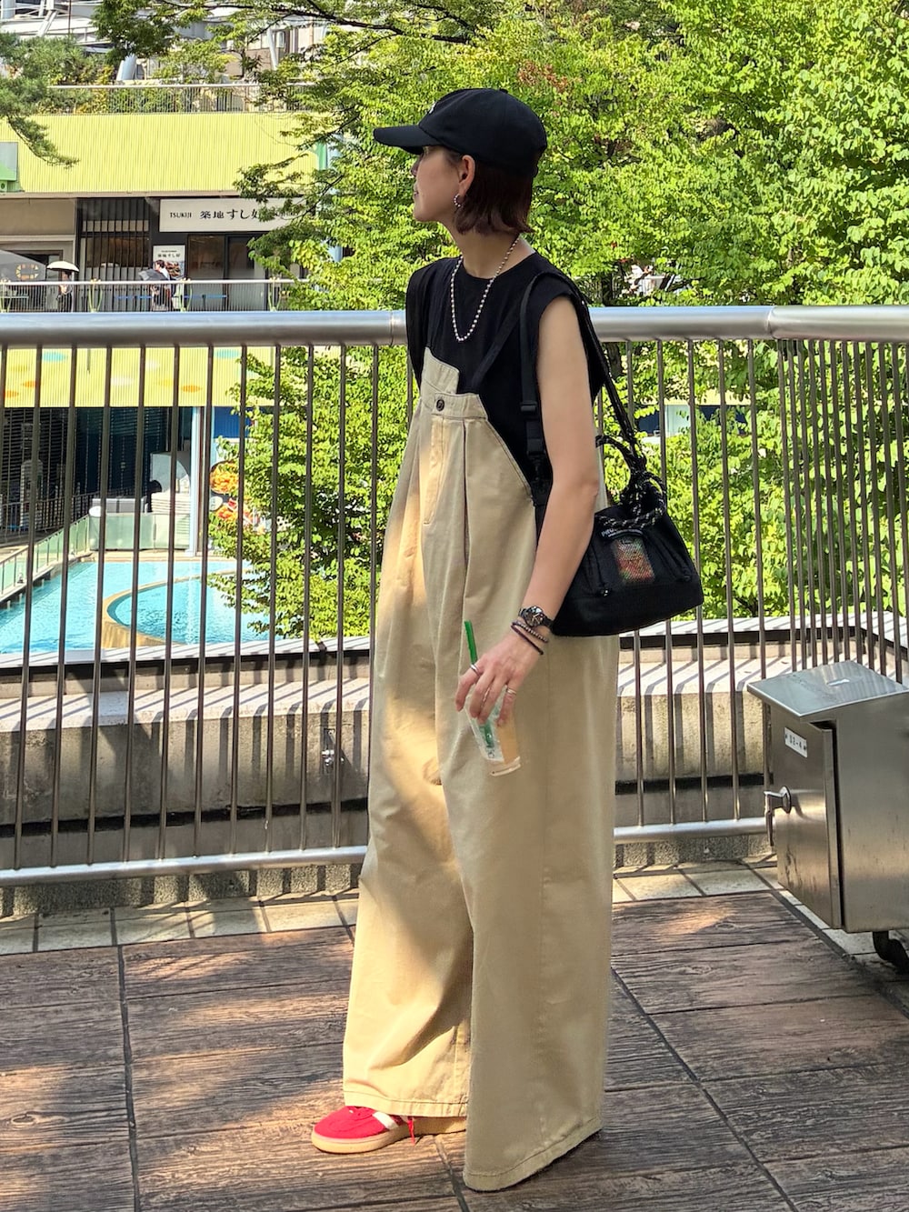 ブラック系のTシャツ/カットソー、ベージュ系のサロペット/オーバーオール、ブラック系のトートバッグを着用したレディースの夏コーディネートの4枚目の写真