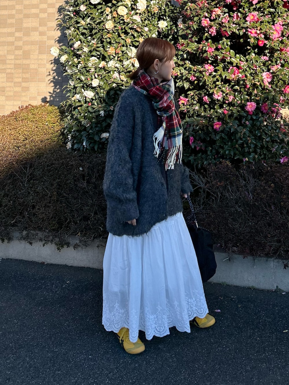 グレー系のTシャツ/カットソー、ホワイト系のスカート、グレー系のカーディガン/ボレロを着用したレディースの冬コーディネートの4枚目の写真