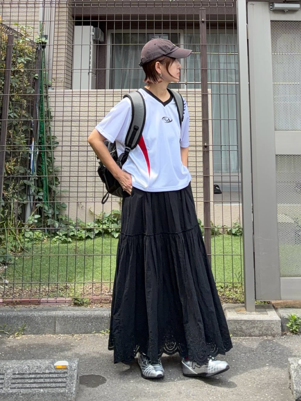 グレー系のバックパック/リュック、ホワイト系のトップス、ブラック系のスカートを着用したレディースの春コーディネートの5枚目の写真