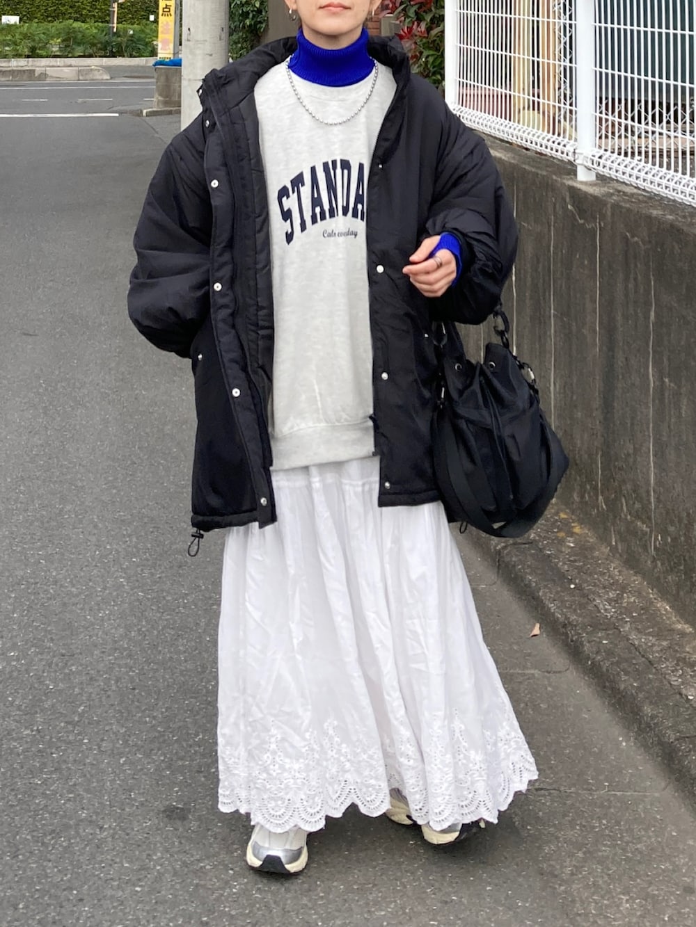 ブラック系のダウンジャケット/コート、ホワイト系のスウェット、ホワイト系のスカートを着用したレディースの秋コーディネートの2枚目の写真