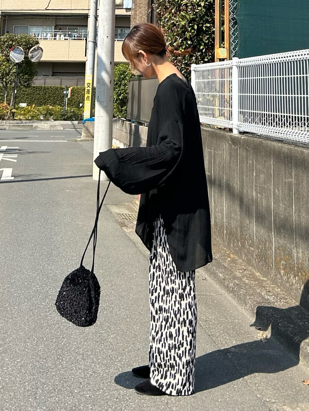 ブラック系のシャツ/ブラウス、ブラック系のショルダーバッグ、ホワイト系のその他パンツを着用したレディースの春コーディネートの4枚目の写真