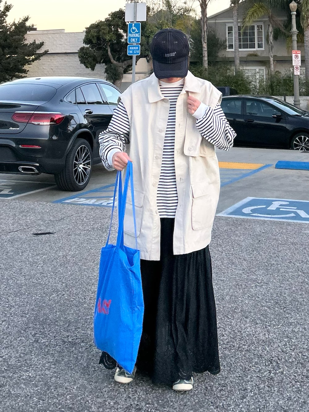 ホワイト系のTシャツ/カットソー、ホワイト系のブルゾン、ブラック系のスカートを着用したレディースの冬コーディネートの2枚目の写真