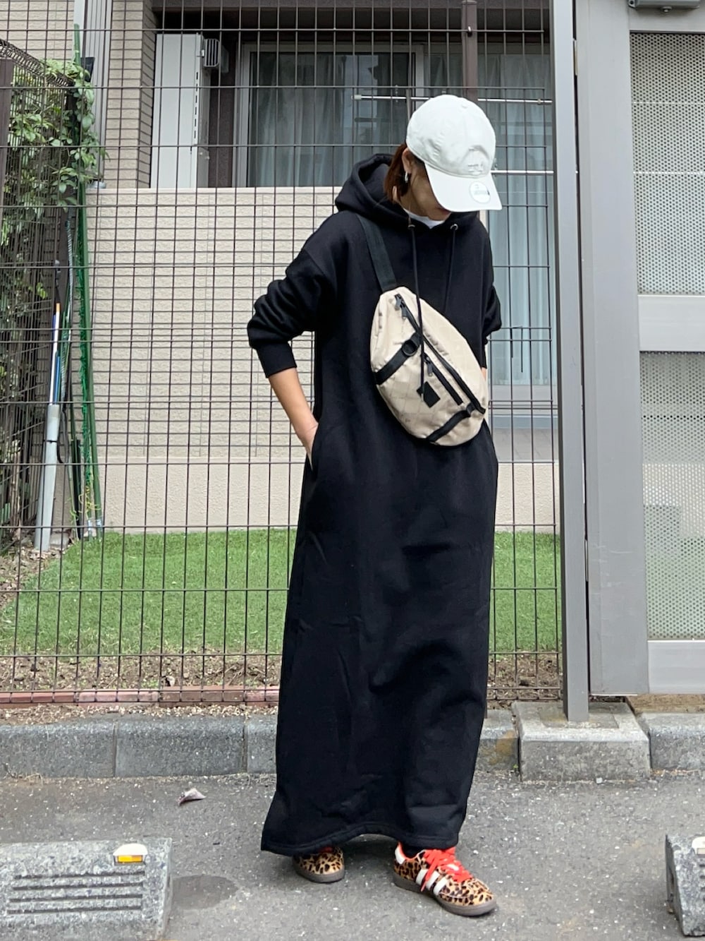 ブラック系のワンピース、その他のショルダーバッグ、ブラック系のスニーカーを着用したレディースの冬コーディネートの3枚目の写真