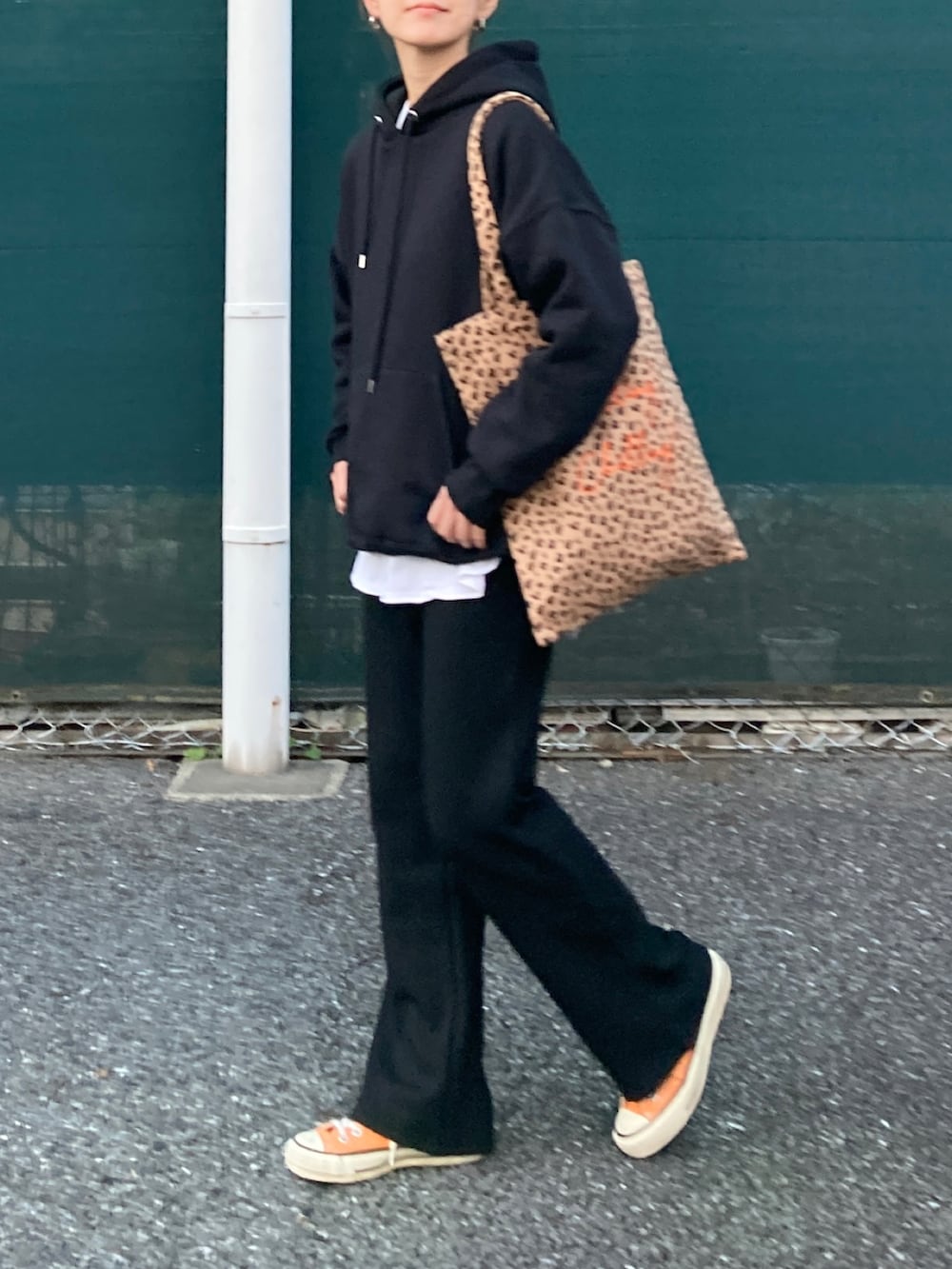 ブラック系のパーカー、ブラック系のその他パンツ、イエロー系のトートバッグを着用したレディースの秋コーディネートの3枚目の写真