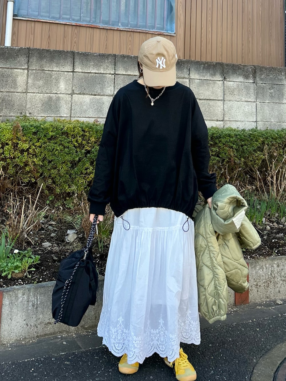 ホワイト系のスカート、シルバー系のトートバッグ、ブラック系のTシャツ/カットソーを着用したレディースの冬コーディネートの4枚目の写真