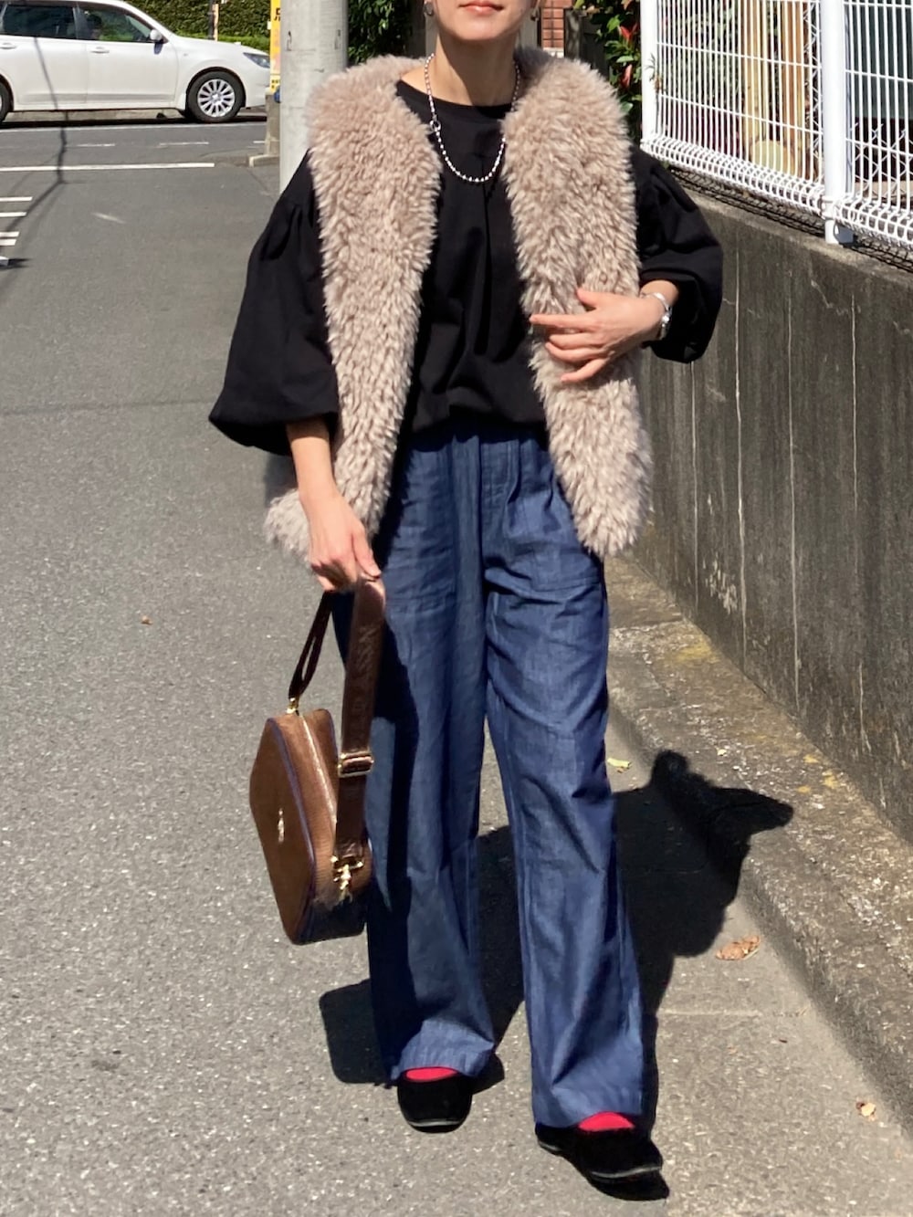 ベージュ系のベスト、ブラック系のTシャツ/カットソー、ブルー系のその他パンツを着用したレディースの秋コーディネートの3枚目の写真