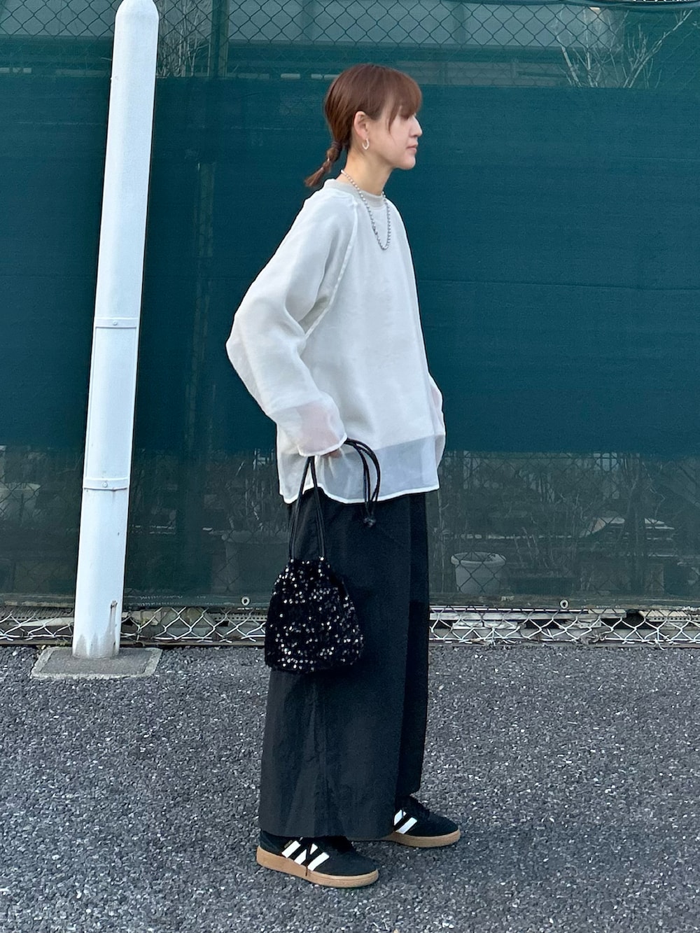 ベージュ系のTシャツ/カットソー、ブラック系のスカート、ブラック系のショルダーバッグを着用したレディースの春コーディネートの2枚目の写真