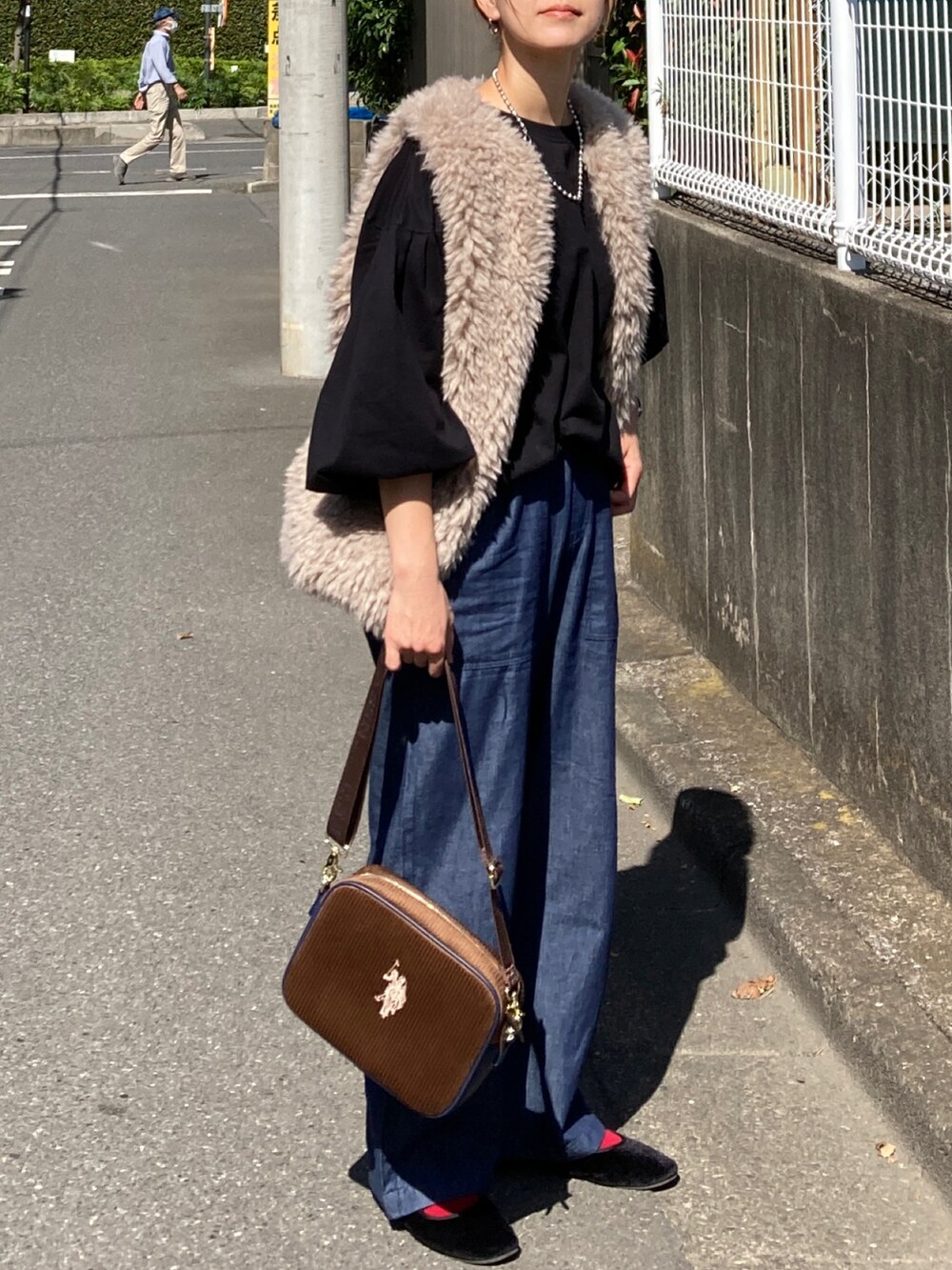 ベージュ系のベスト、ブラック系のTシャツ/カットソー、ブルー系のその他パンツを着用したレディースの秋コーディネートの2枚目の写真