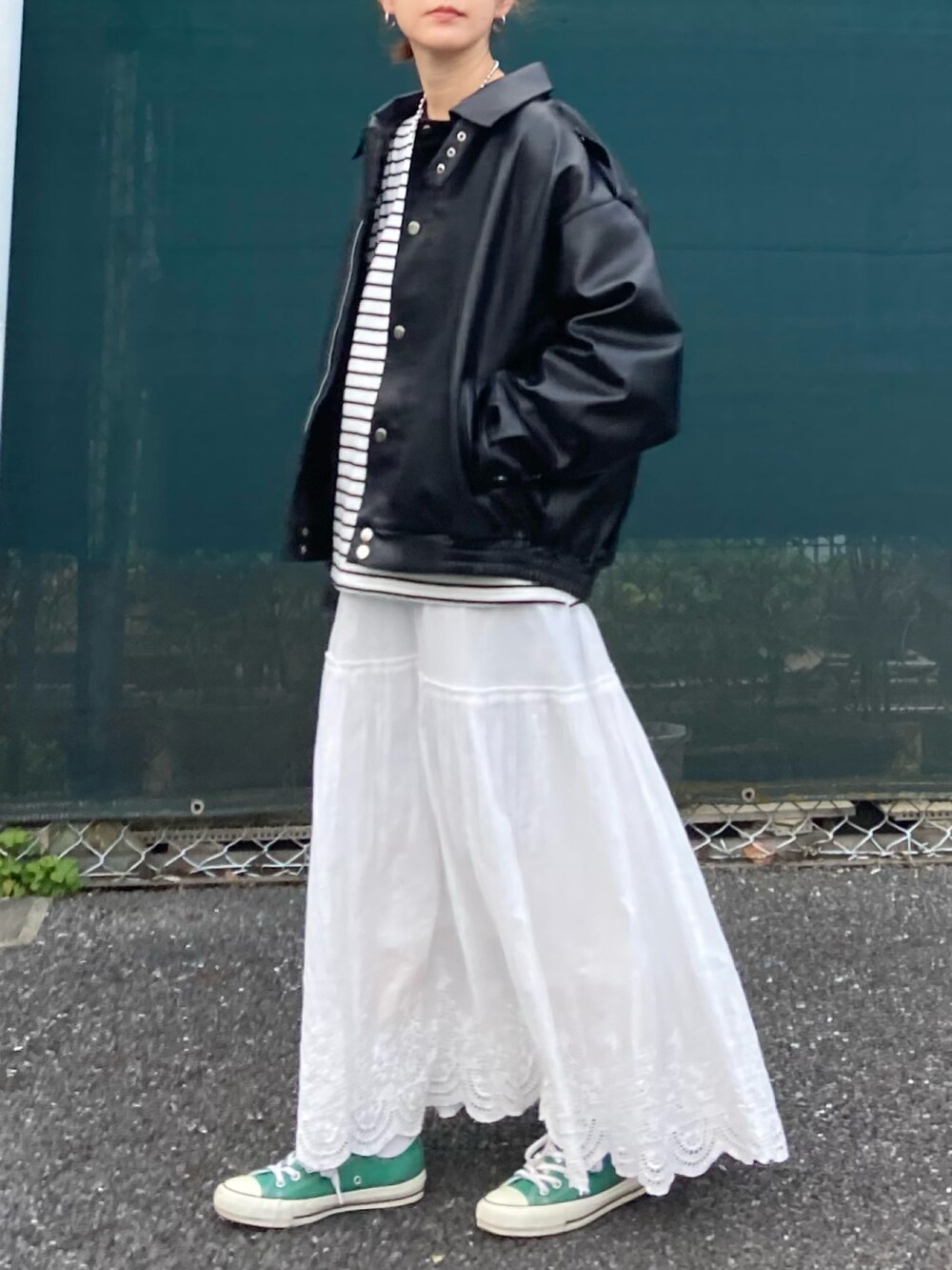 ブラック系のブルゾン、ブラック系のTシャツ/カットソー、ホワイト系のスカートを着用したレディースの春コーディネートの4枚目の写真