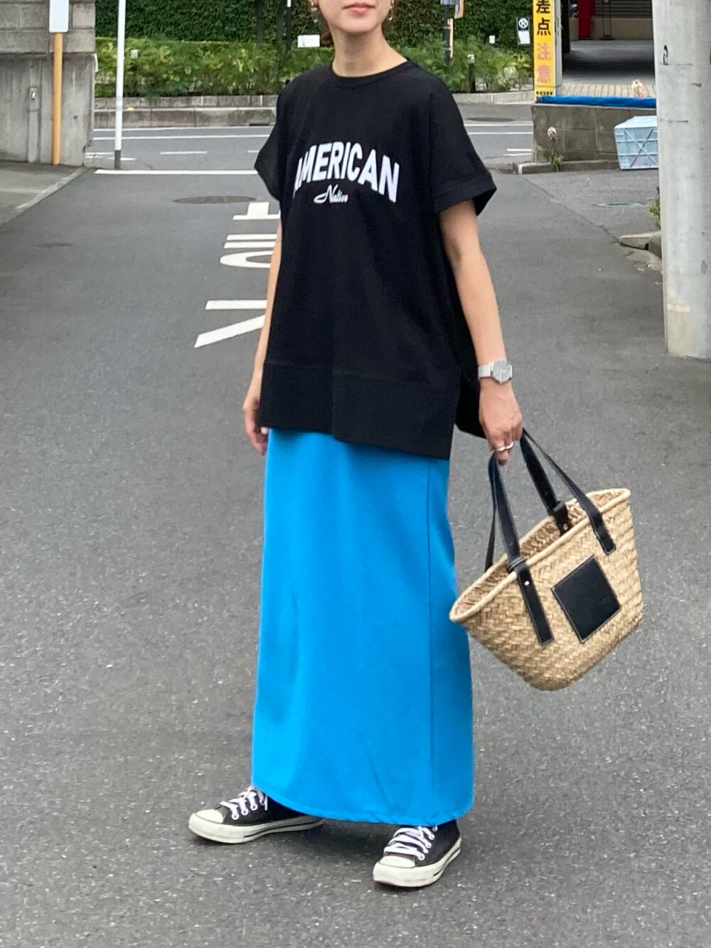 ブラック系のTシャツ/カットソー、ブルー系のスカート、ブラック系のかごバッグを着用したレディースの夏コーディネートの3枚目の写真