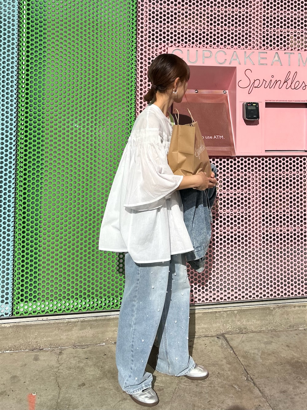 ホワイト系のシャツ/ブラウス、グリーン系のトートバッグ、シルバー系のスニーカーを着用したレディースの春コーディネートの2枚目の写真