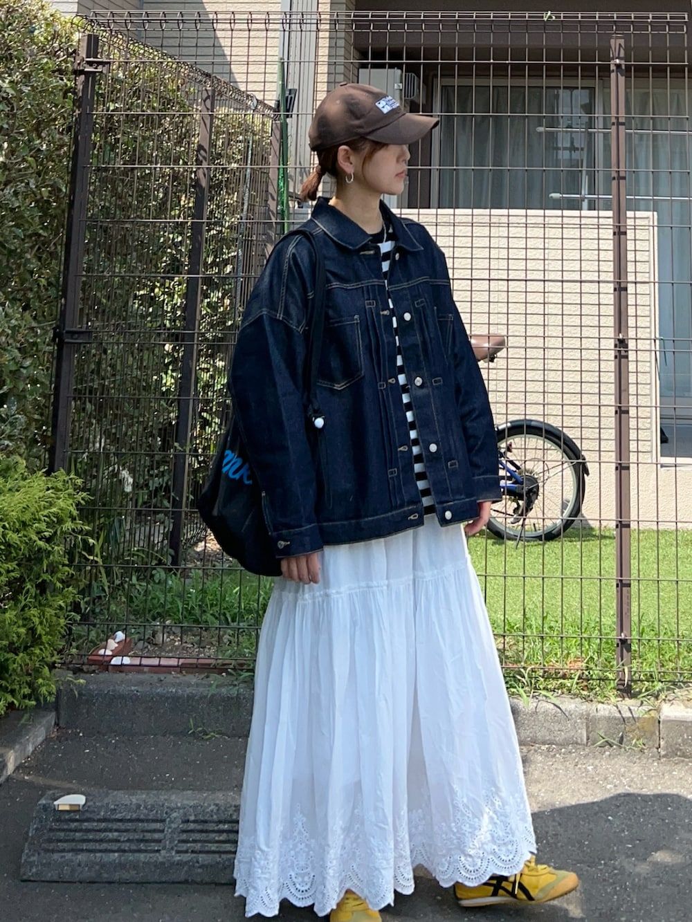 ブラック系のTシャツ/カットソー、ブルー系のデニムジャケット、ブラック系のトートバッグを着用したレディースの秋コーディネートの3枚目の写真