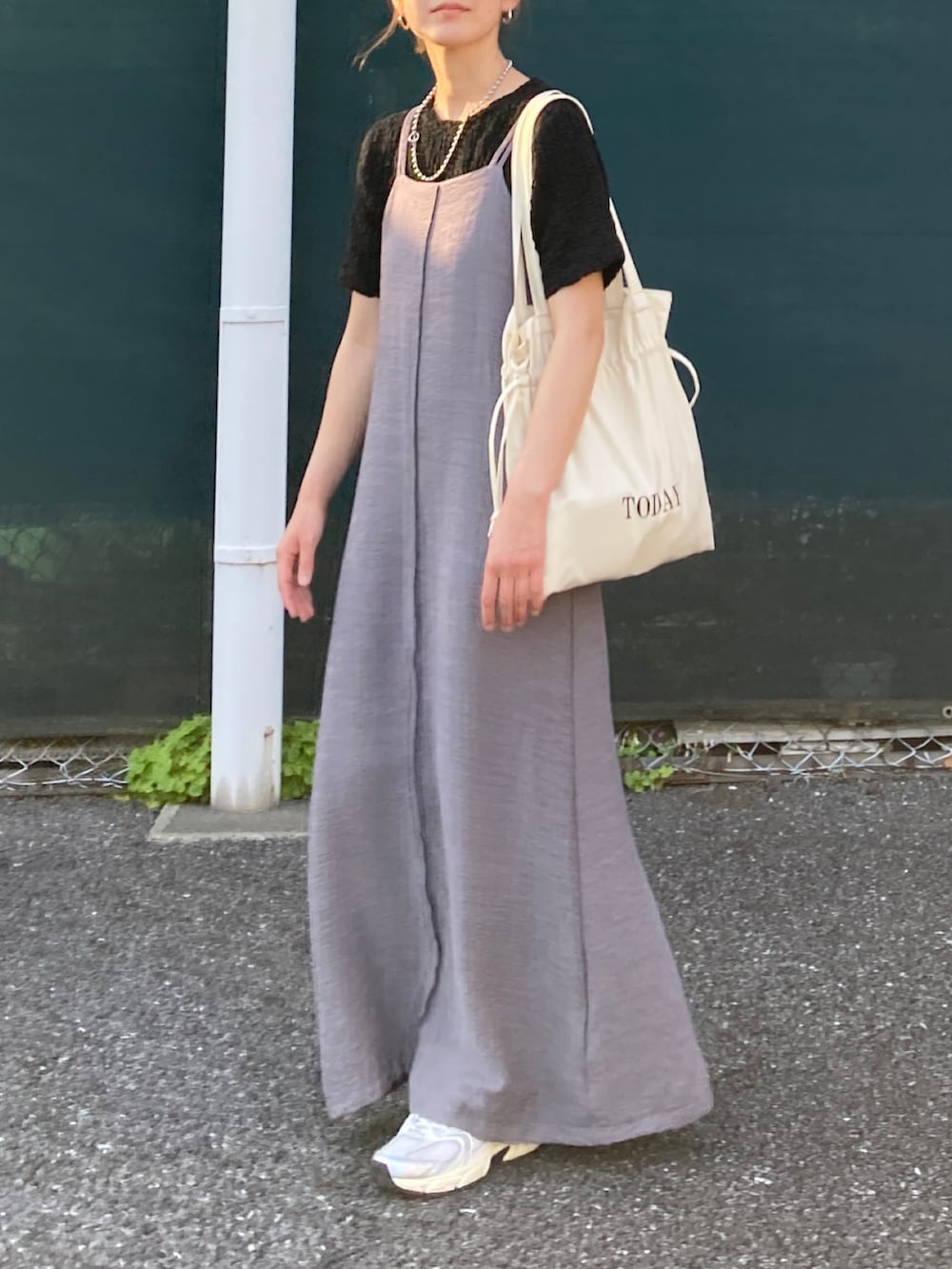ブラック系のTシャツ/カットソー、グレー系のワンピース、ホワイト系のトートバッグを着用したレディースの春コーディネートの3枚目の写真