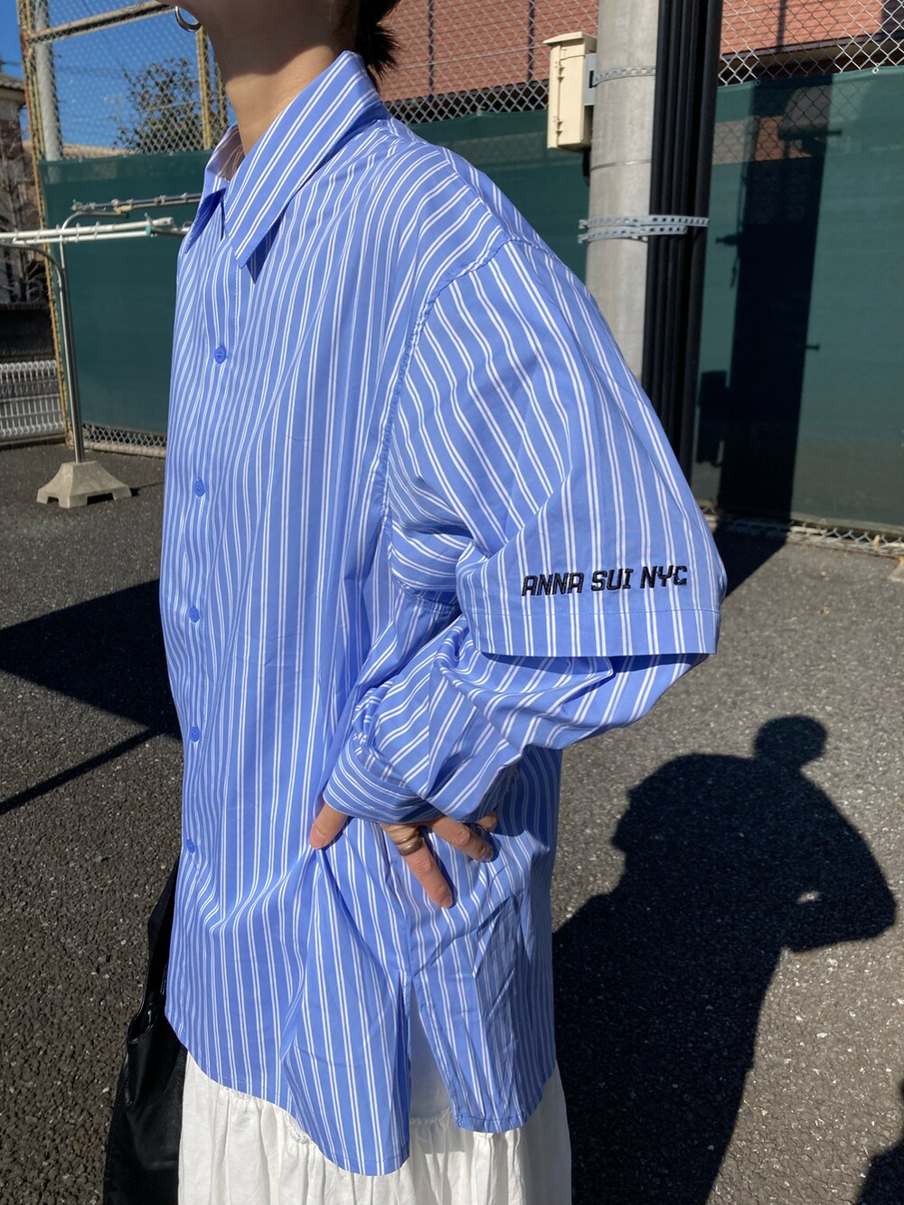 ブラック系のダウンベスト、ブルー系のシャツ/ブラウス、ブラック系のトートバッグを着用したレディースの冬コーディネートの4枚目の写真