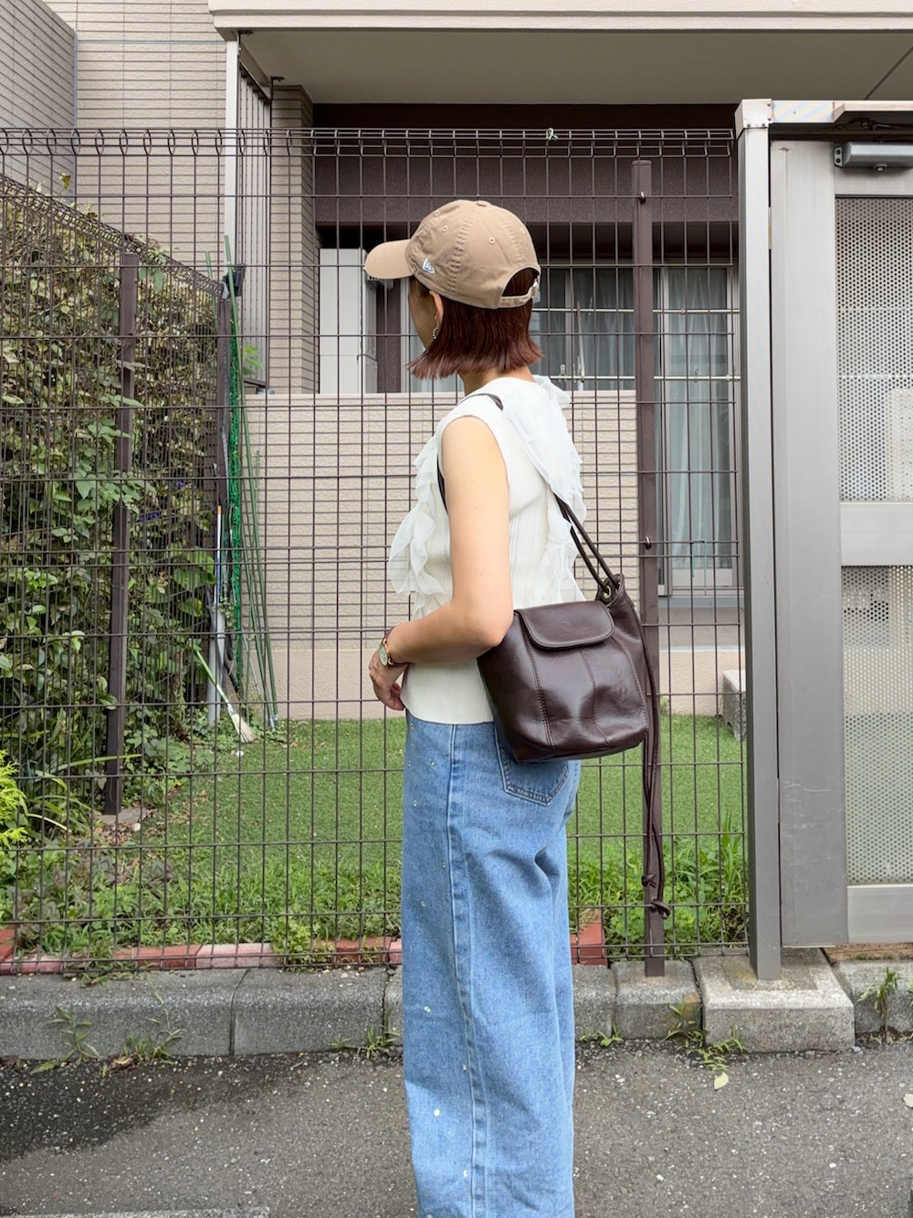 ホワイト系のカーディガン/ボレロ、ブルー系のデニムパンツ、ブラウン系のショルダーバッグを着用したレディースの夏コーディネートの4枚目の写真