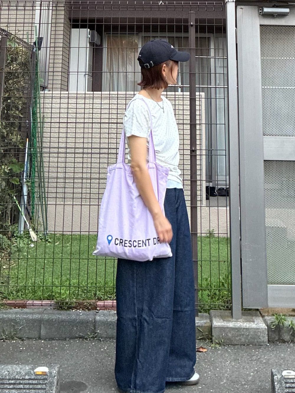ホワイト系のTシャツ/カットソー、パープル系のトートバッグ、ブルー系のデニムパンツを着用したレディースの夏コーディネートの4枚目の写真