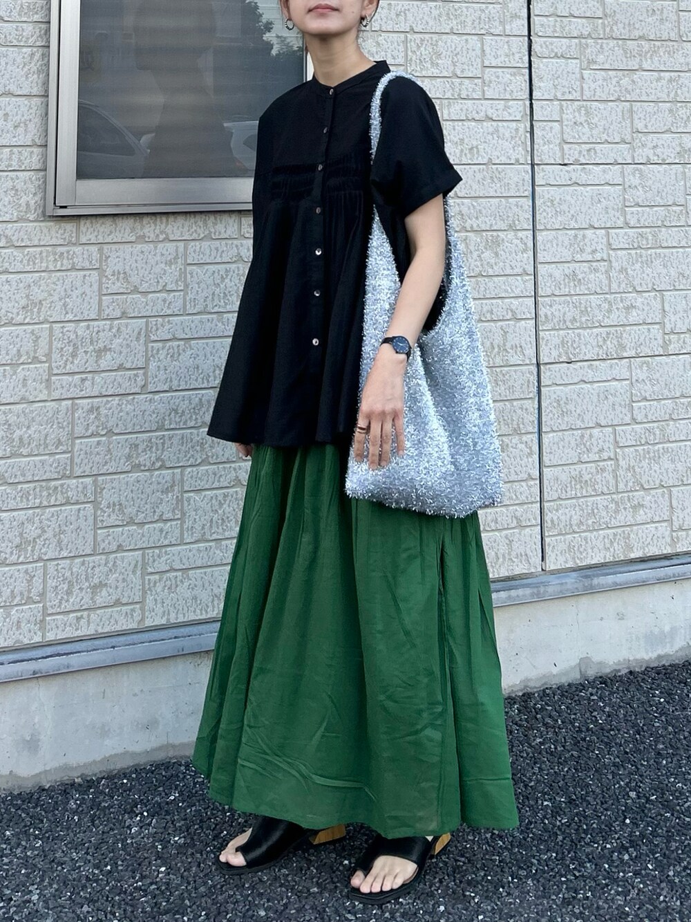 ブラック系のシャツ/ブラウス、グリーン系のスカート、シルバー系のトートバッグを着用したレディースの夏コーディネートの5枚目の写真