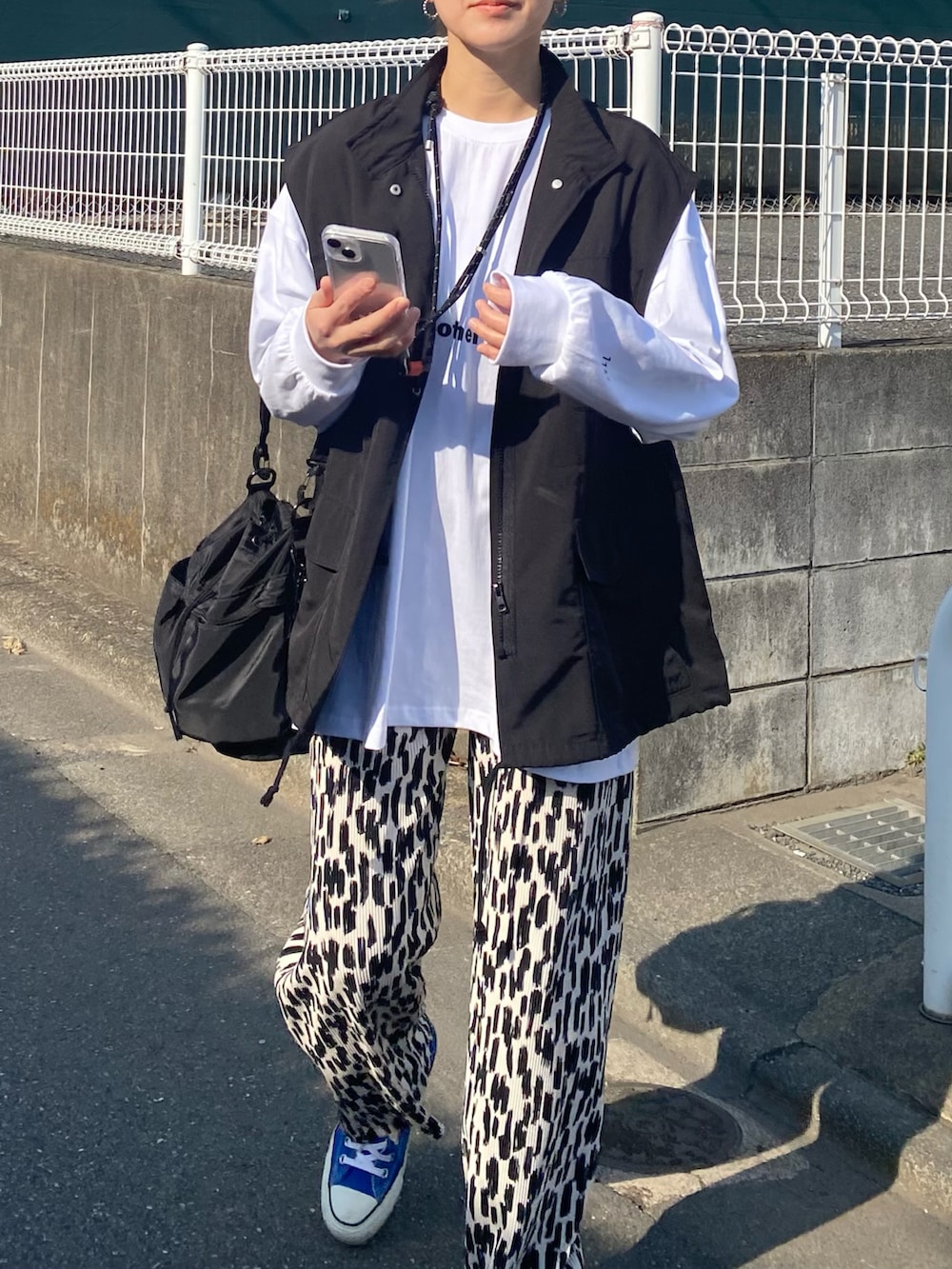「春のおしゃ見えテクニック、春コーデ、春アウター、春服みてみて、モノトーン、ベスト、ロンT、ロゴT、プリーツパンツ、スニーカー、プチプラ、大人カジュアル、きれいめカジュアル、お出かけコーデ、アウトドアスタイル」|「recaの【お気に入り数3.2万人突破!】ゆるっとルーズ感!オーバーサイズロゴロンT(Tシャツ/カットソー、ホワイト系)」を使った、KRさん(レディース・159cm)の春コーディネートの4枚目の写真