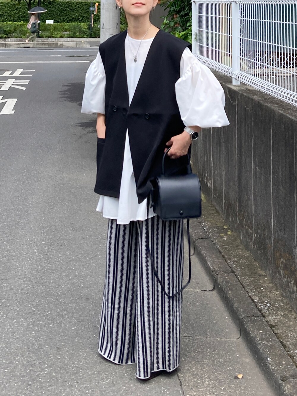 ブラック系のベスト、ホワイト系のシャツ/ブラウス、グレー系のその他パンツを着用したレディースの秋コーディネートの2枚目の写真