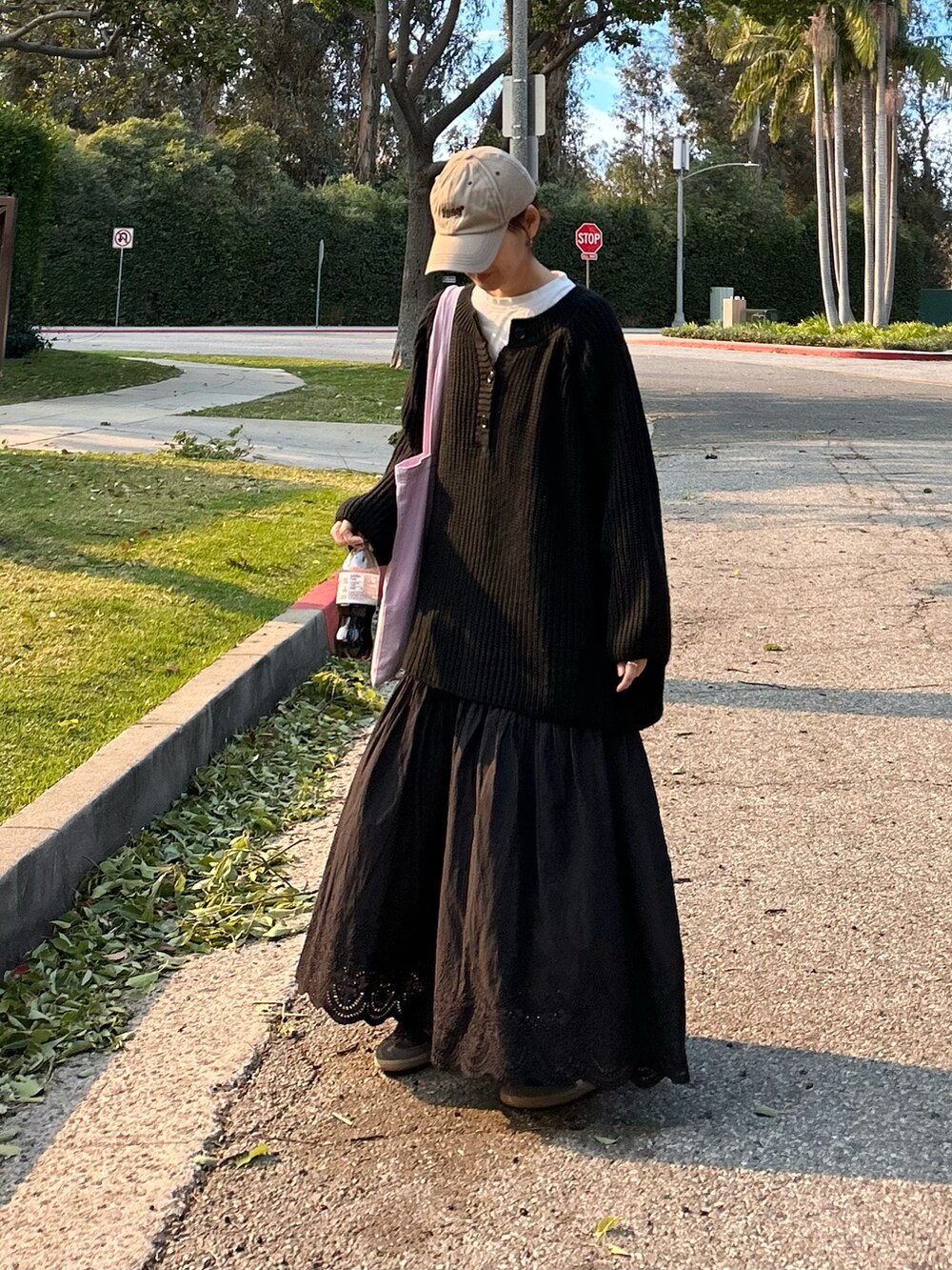 ブラック系のニット/セーター、ブラック系のスカート、パープル系のトートバッグを着用したレディースの冬コーディネートの2枚目の写真