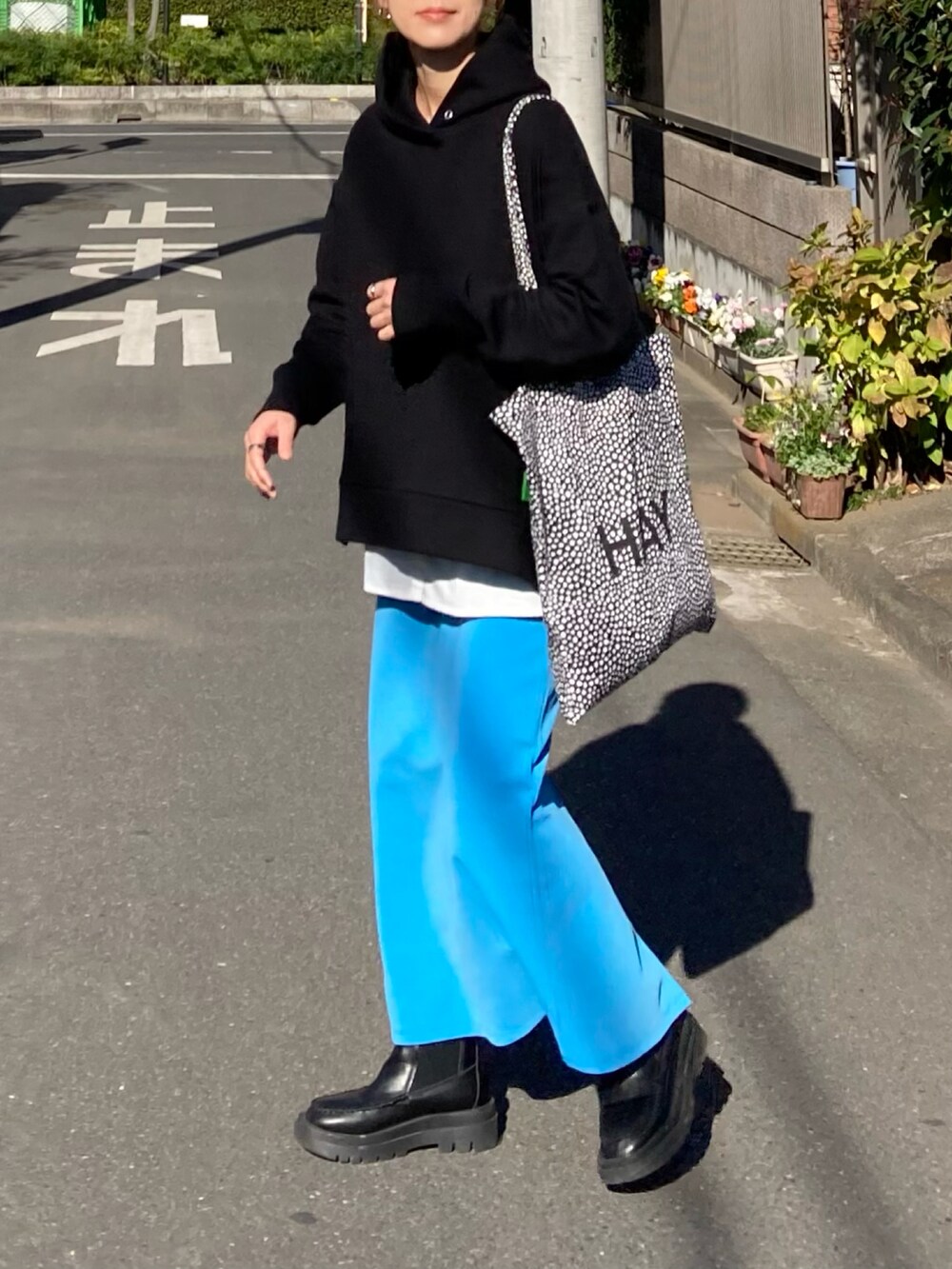 ブラック系のブルゾン、ブラック系のパーカー、ブルー系のスカートを着用したレディースの冬コーディネートの3枚目の写真