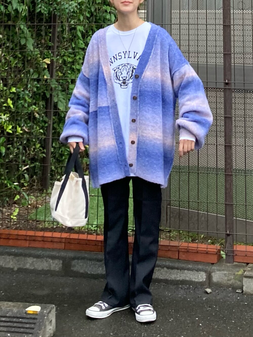 ブルー系のカーディガン/ボレロ、ホワイト系のTシャツ/カットソー、ブラック系のスラックスを着用したレディースの秋コーディネートの3枚目の写真