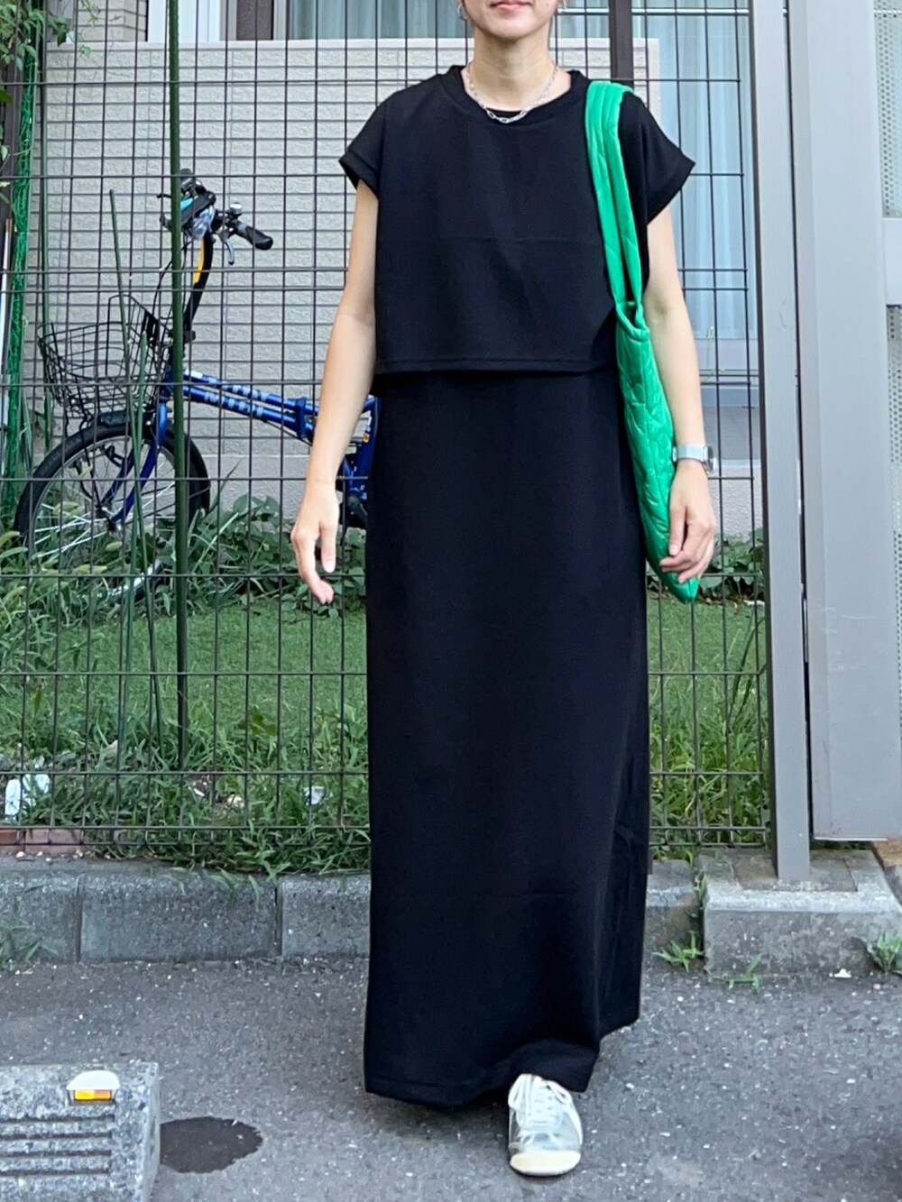 ブラック系のジャンパースカート、グリーン系のトートバッグ、シルバー系のスニーカーを着用したレディースの夏コーディネートの4枚目の写真