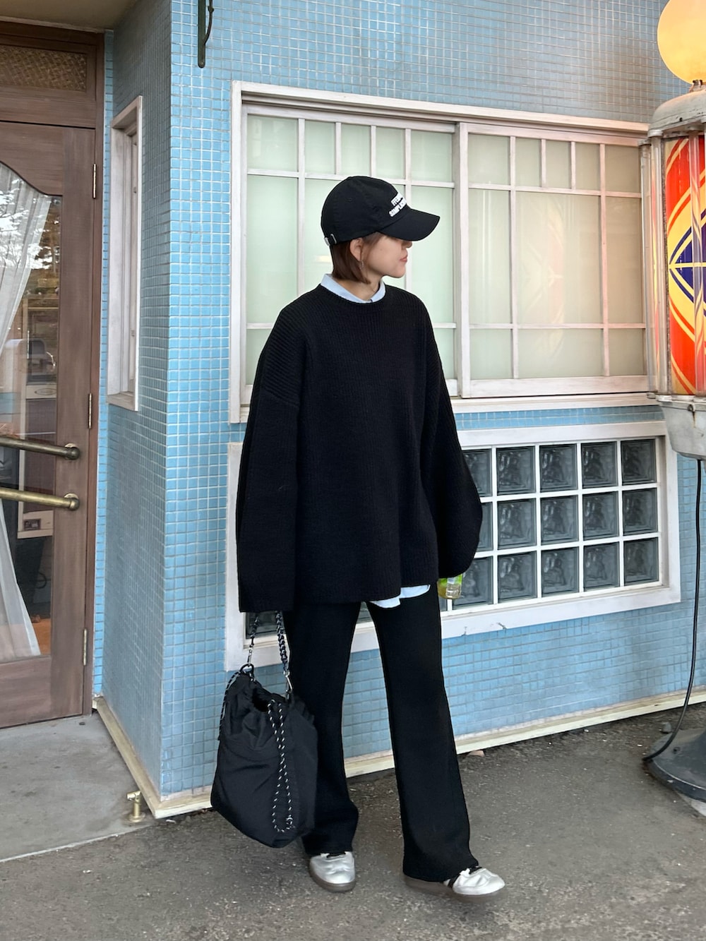 ブラック系のニット/セーター、ブラック系のその他パンツ、ブラック系のトートバッグを着用したレディースの冬コーディネートの5枚目の写真