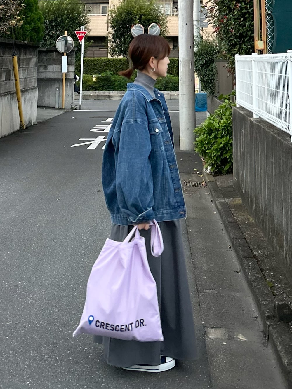 グレー系のワンピース、パープル系のトートバッグ、ブルー系のデニムジャケットを着用したレディースの冬コーディネートの2枚目の写真