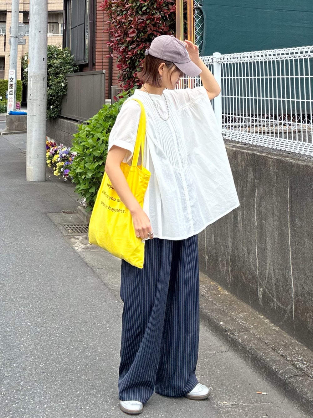 ホワイト系のシャツ/ブラウス、ブルー系のスラックス、イエロー系のトートバッグを着用したレディースの春コーディネートの3枚目の写真