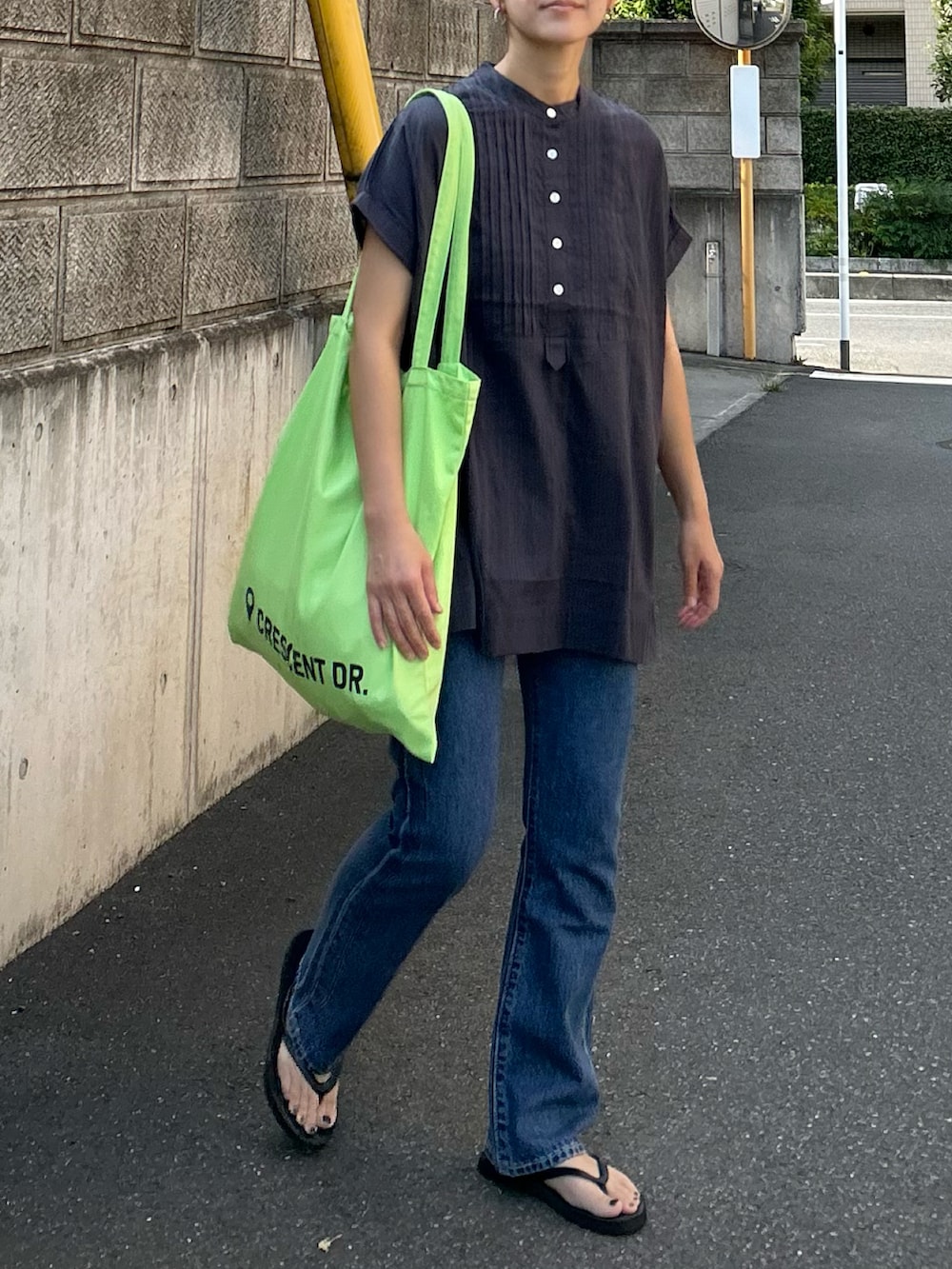 ブルー系のデニムパンツ、グレー系のシャツ/ブラウス、グリーン系のトートバッグを着用したレディースの夏コーディネートの3枚目の写真