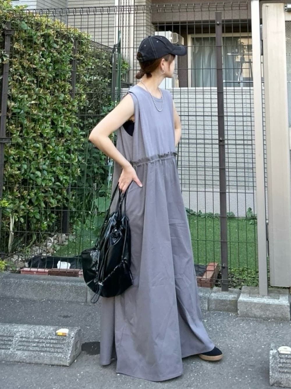 グレー系のワンピース、ブラック系のバックパック/リュック、ブラック系のキャップを着用したレディースの夏コーディネートの5枚目の写真