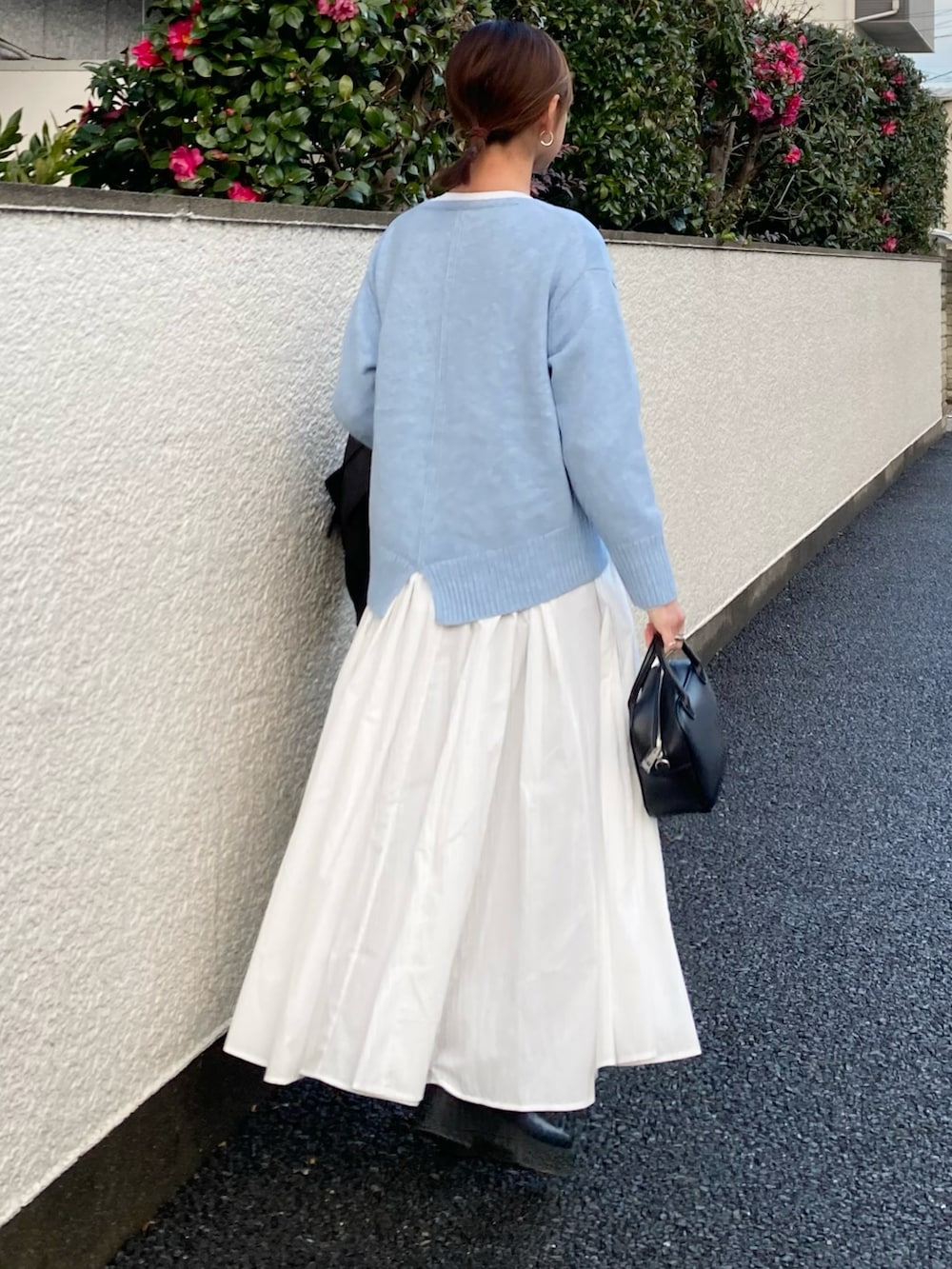 ブルー系のニット/セーター、ホワイト系のシャツワンピース、ブラック系のボストンバッグを着用したレディースの冬コーディネートの4枚目の写真