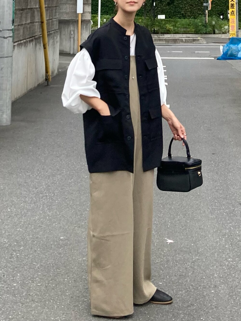 ブラック系のシャツ/ブラウス、ベージュ系のサロペット/オーバーオール、ホワイト系のシャツ/ブラウスを着用したレディースの夏コーディネートの2枚目の写真