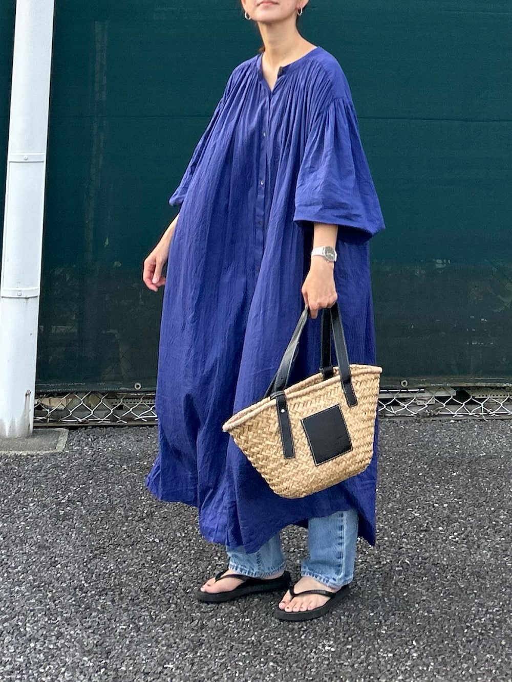 ブルー系のワンピース、ブラック系のかごバッグを着用したレディースの夏コーディネートの2枚目の写真