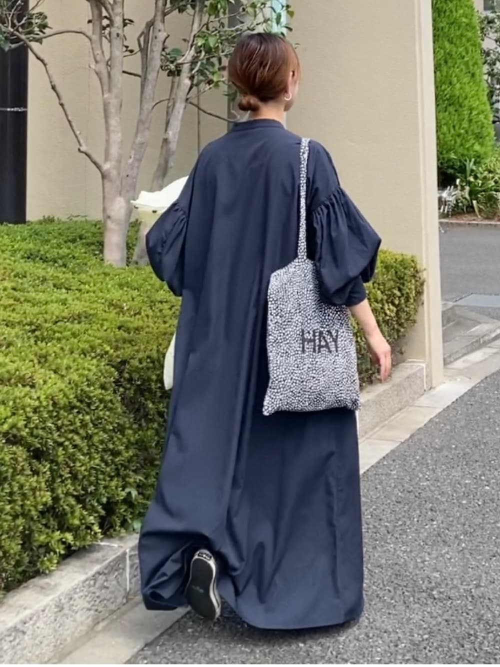 ブルー系のワンピース、ブラック系のトートバッグ、イエロー系のスニーカーを着用したレディースの秋コーディネートの3枚目の写真