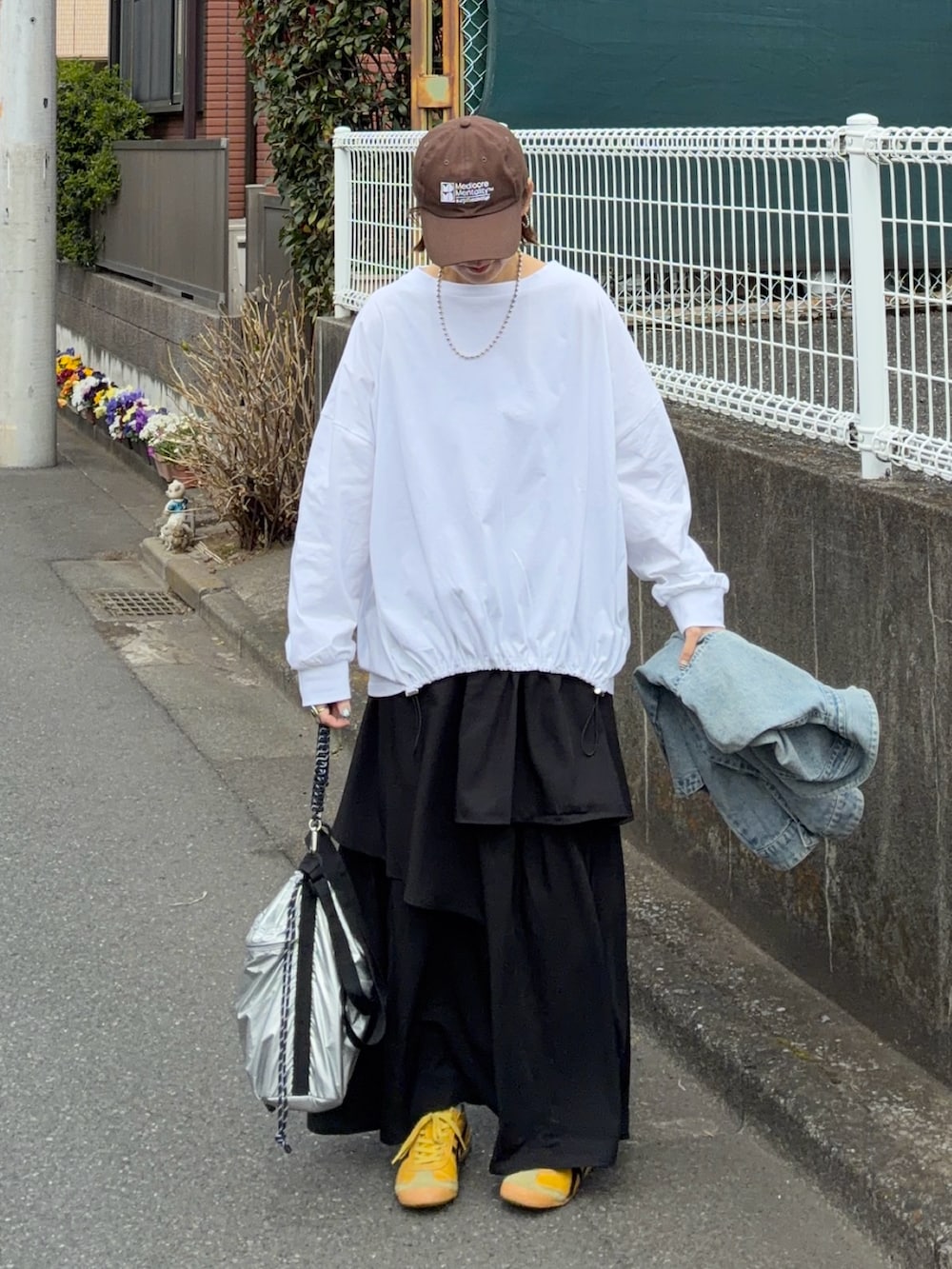 ホワイト系のTシャツ/カットソー、ブラック系のスカート、シルバー系のトートバッグを着用したレディースの春コーディネートの5枚目の写真