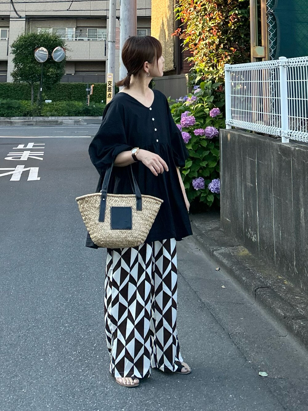 ブラック系のチュニック、ブラウン系のその他パンツ、ブラック系のかごバッグを着用したレディースの夏コーディネートの3枚目の写真