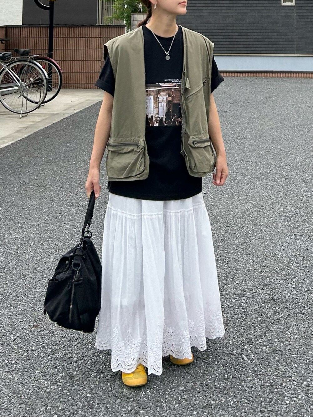 ブラック系のTシャツ/カットソー、ホワイト系のスカート、ブラック系のショルダーバッグを着用したレディースの夏コーディネートの2枚目の写真