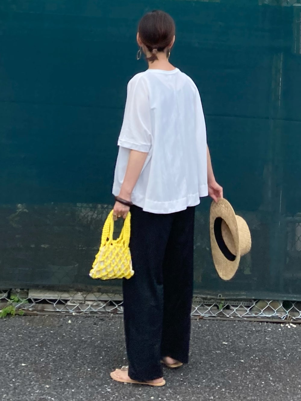 ホワイト系のTシャツ/カットソー、ブラック系のその他パンツ、イエロー系のハンドバッグを着用したレディースの春コーディネートの5枚目の写真
